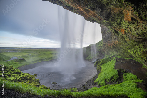 Beautiful view of Seljalandsfoss in Iceland on summer morning. View behind the water curtain of the waterfall.