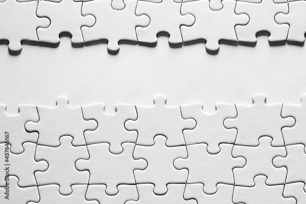 Blank white background space surrounded by white jigsaw puzzle pieces with copy space. Blank white background space surrounded by white jigsaw puzzle pieces with copy space.