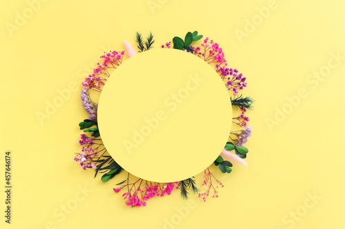 Top view image of pink, purple and green flowers composition over pastel yellow background .Flat lay