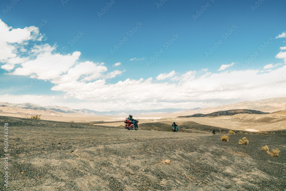 Obraz premium Motorcyclists ride in Death Valley, Ubehebe Crater viewpoint. Volcanic landscape, Extreme Sport, Active lifestyle, Adventure concept