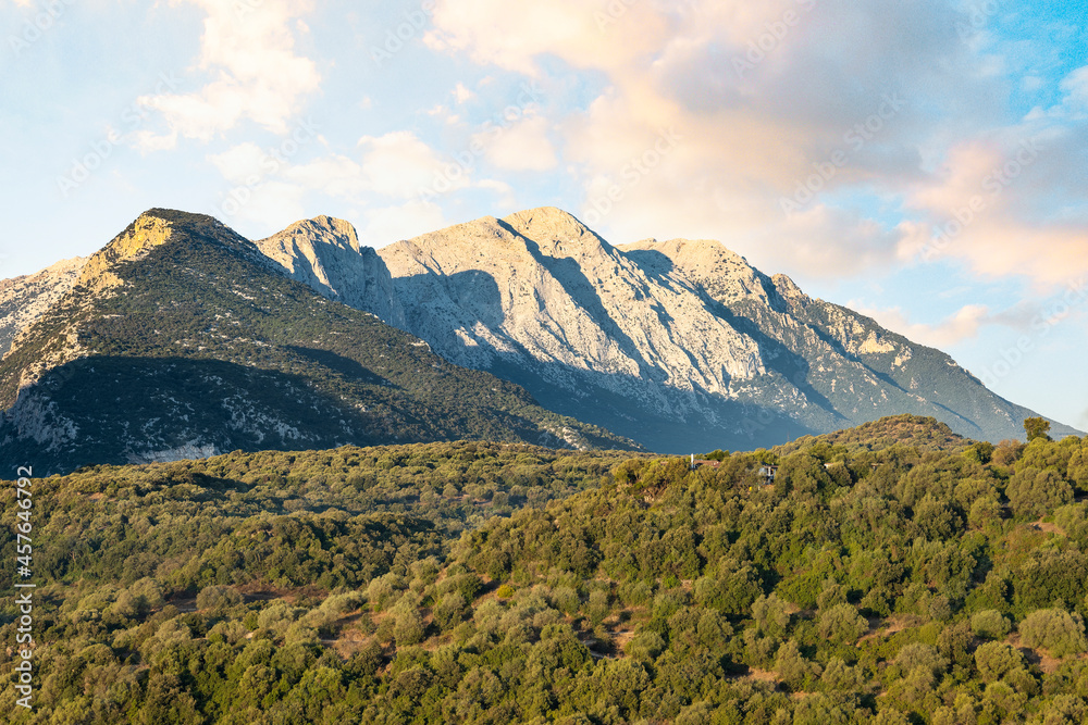 Fototapeta premium Stunning view of the Cedrino Lake (Lago del Cedrino) with the mountain range of Supramonte illuminated by a beautiful sunrise. Sardinia, Italy.