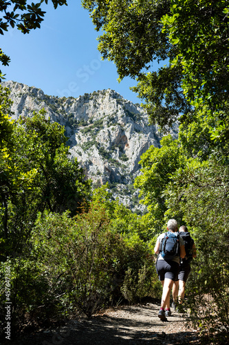 Stunning view of two people walking on a trail leading to Gorropu gorge. Gorropu is the most spectacular and deepest canyon in Europe and it is located in the Supramonte area  Sardinia  Italy.