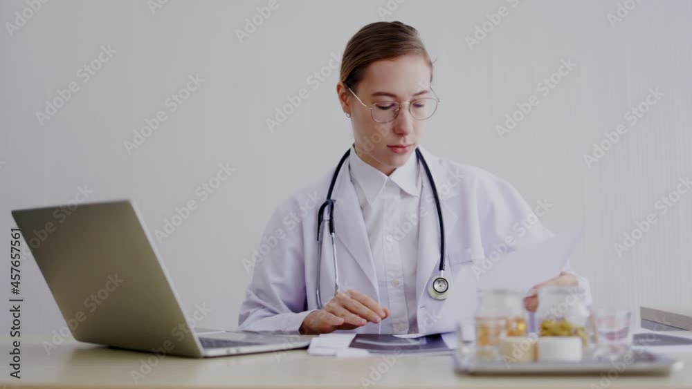 Caucasian female doctor sit and search patient information from laptop computer in hospital office. Active professional work. Specialist in treatment of specific diseases. medical care orthopedic Caucasian female doctor sit and search patient information from laptop computer in hospital office. Active professional work. Specialist in treatment of specific diseases. medical care orthopedic