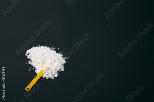 sports supplement creatine powder on black background copy space