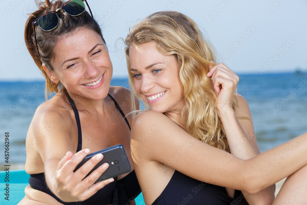 female friends taking selfie on the beach
