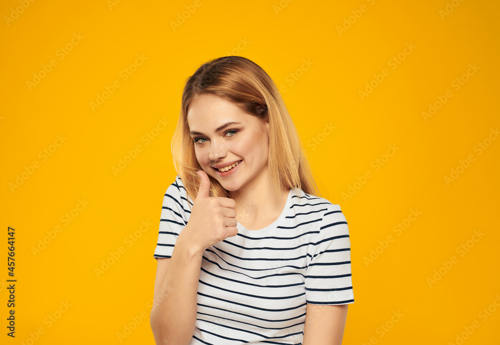 pretty woman in striped t-shirt gesturing with hands joy yellow background pretty woman in striped t-shirt gesturing with hands joy yellow background