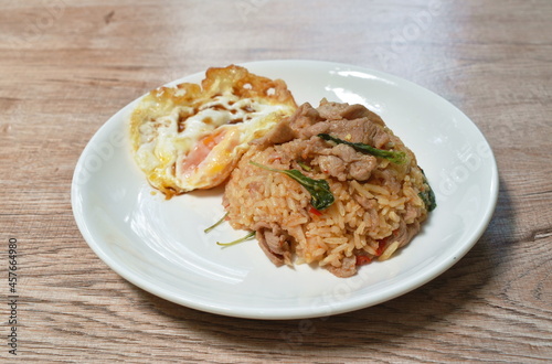 spicy stir fried slice pork with chili and basil leaf mixed rice topping egg on plate 