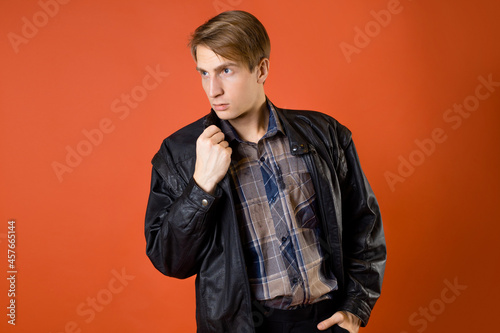 a guy in a casual plaid shirt and a leather jacket, studio photo