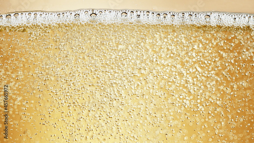 Close-up of champagne bubbles background with foam.