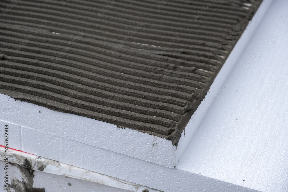 Installation of styrofoam insulation sheets on house facade wall for thermal protection. Installation of styrofoam insulation sheets on house facade wall for thermal protection.