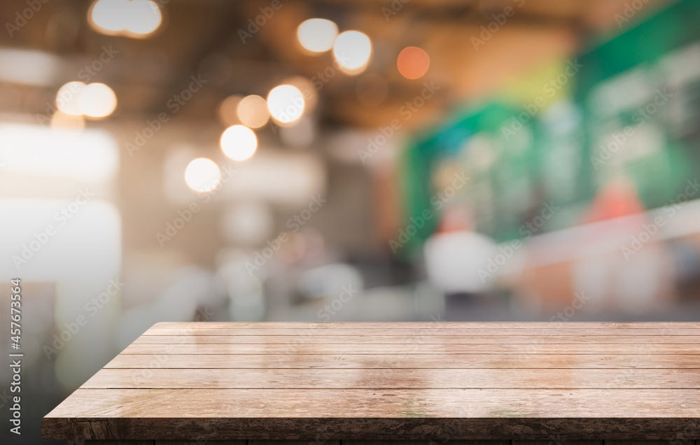 Empty wooden table top with lights bokeh on blur restaurant background.