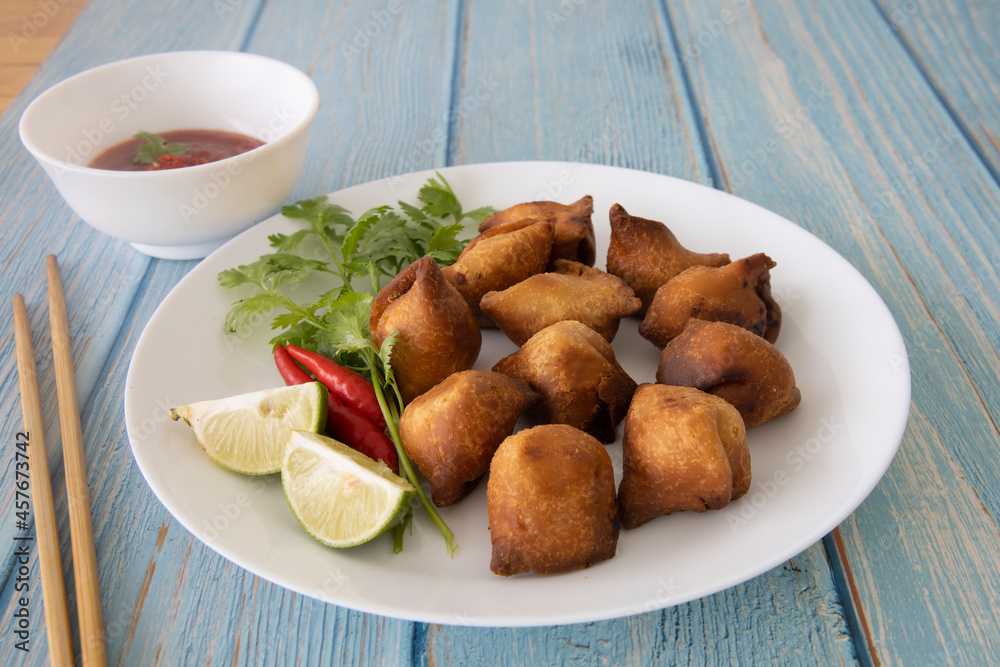Vegetarian Samosa with potato filling on wooden table Vegetarian Samosa with potato filling on wooden table