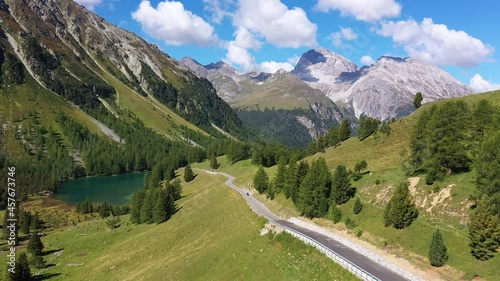 Aerial drone footage of the Albula mountain pass road in the alps in Canton Graubunden in Switzerland. Shot with a following motion of a motorcycle  photo
