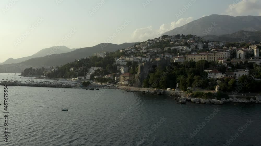 4K Town on the coast of the Mediterranean sea. Drone shot. The coastline of tourist holiday destinations. Aerial drone view of Herceg Novi on the sloping shore of Boka Kotor bay in Montenegro, Eu. 4K Town on the coast of the Mediterranean sea. Drone shot. The coastline of tourist holiday destinations. Aerial drone view of Herceg Novi on the sloping shore of Boka Kotor bay in Montenegro, Eu.