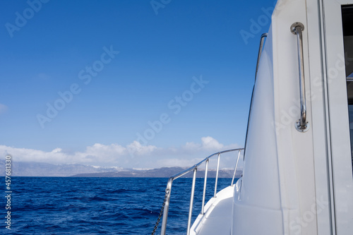 Vacation on a white yacht in the sea. The silhouette of an island in the distance.