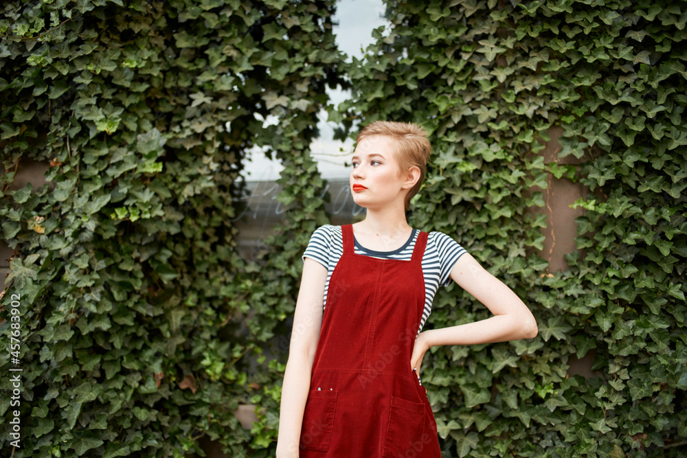 pretty woman with short hair outdoors on a background of bushes pretty woman with short hair outdoors on a background of bushes