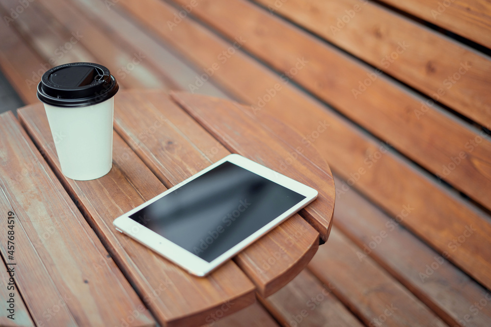 Tablet and coffee with you on a wooden table in a coffee shop