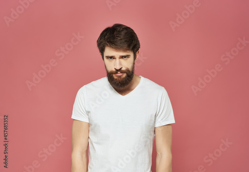 upset man in white t-shirt studio dissatisfaction pink background