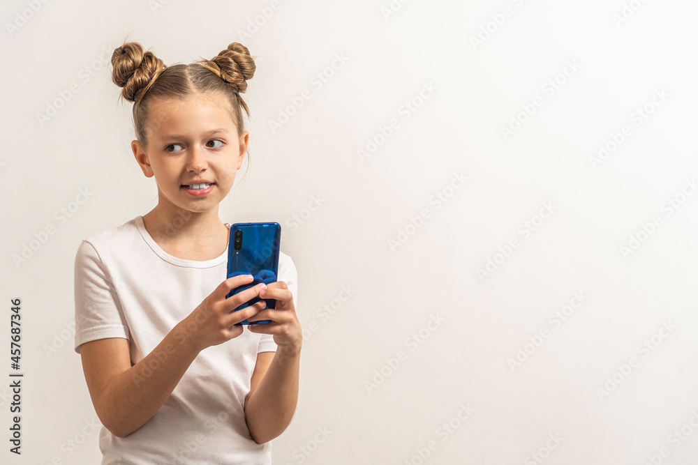 girl with dark hair hold the phone and laugh on the light background. girl with dark hair hold the phone and laugh on the light background.