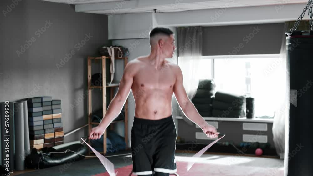 Shirtless young man jumping over the rope in bright gym Stock Video ...