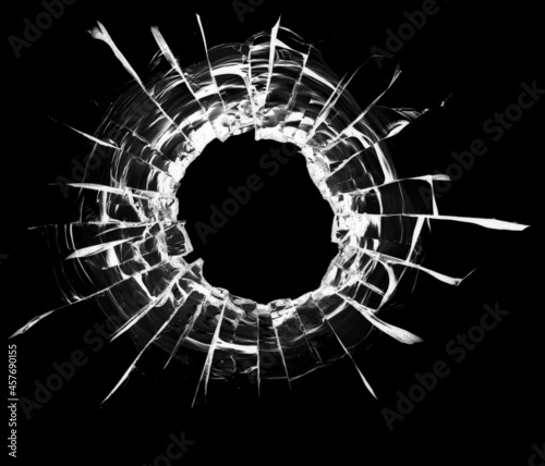 Foto Bullet hole in the glass. Isolated on a black background.