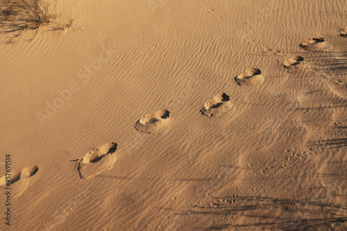 Fototapeta Naklejka Na Ścianę i Meble -  Trail of footprints on sand in desert