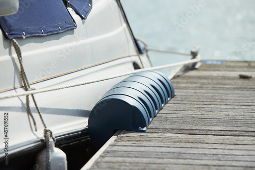 Long pier blue fenders for a boat and dockside for protection. Maritime fenders