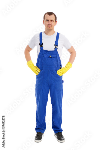 full length portrait of male cleaner in blue uniform and yellow gloves posing isolated on white