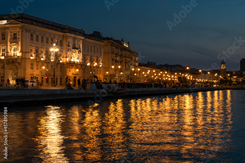 sea coast in Trieste Italy with beautiful illuminated buildings and reflection on the water