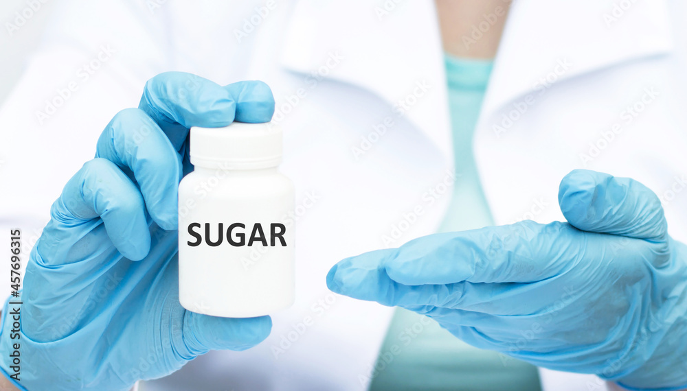 Sugar text on a white jar in the hands of a doctor, a blue gloved hand plan. The threat and treatment of diabetes mellitus Sugar text on a white jar in the hands of a doctor, a blue gloved hand plan. The threat and treatment of diabetes mellitus