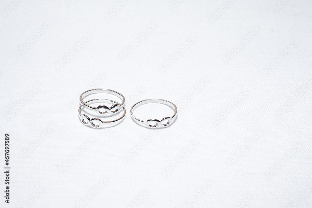 Infinity symbol rings on white cloth background