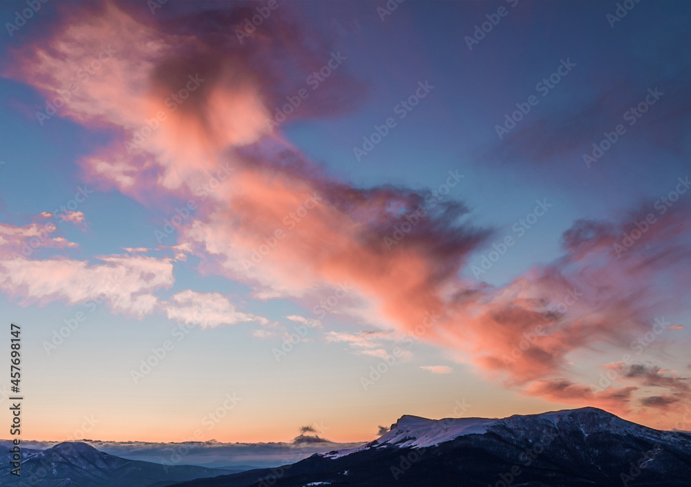Scenic sunset in the Alps. Picturesque sunset in the mountains. Pink clouds in the blue sky. High quality photo