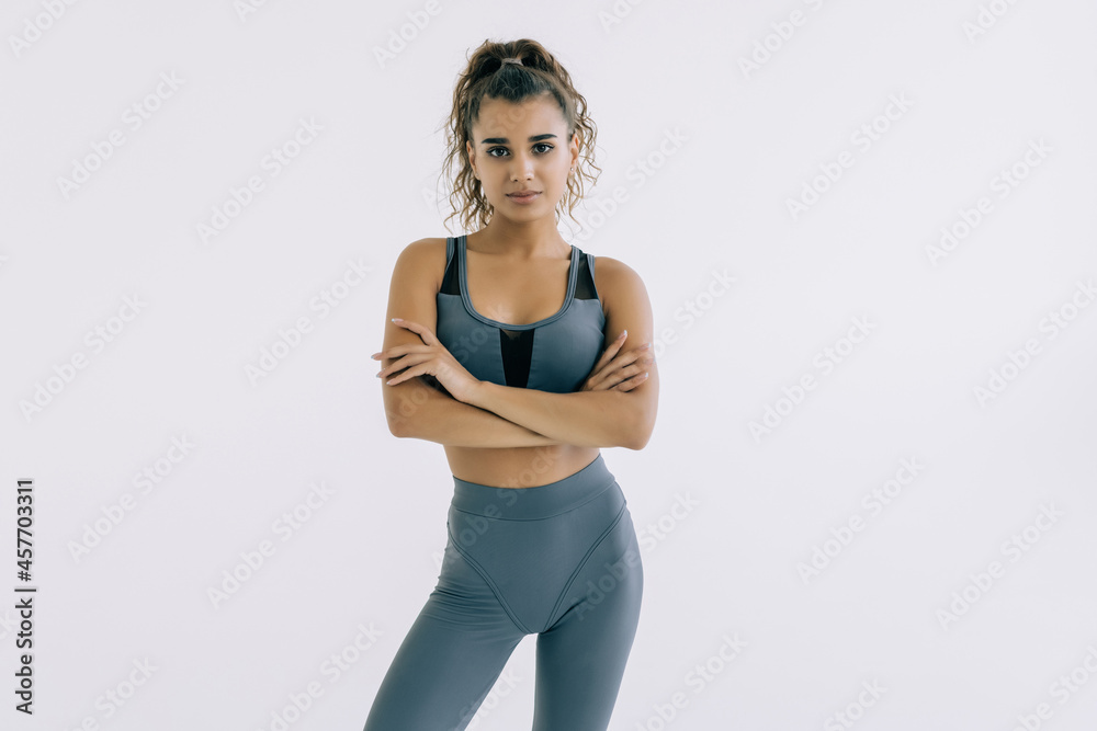 Smiling sports woman standing isolated on a white background Smiling sports woman standing isolated on a white background