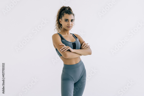 fitness woman in sport style standing against white background.