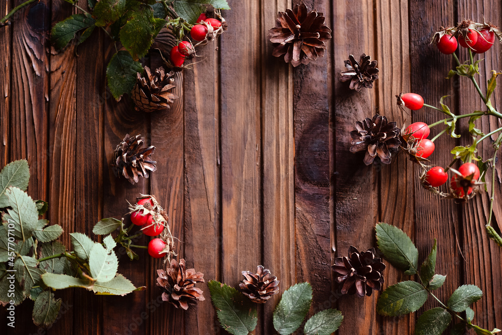 Сhristmas decoration on wooden background. Cones, needles, rose hips. Warm and cozy postcard. Сhristmas decoration on wooden background. Cones, needles, rose hips. Warm and cozy postcard.