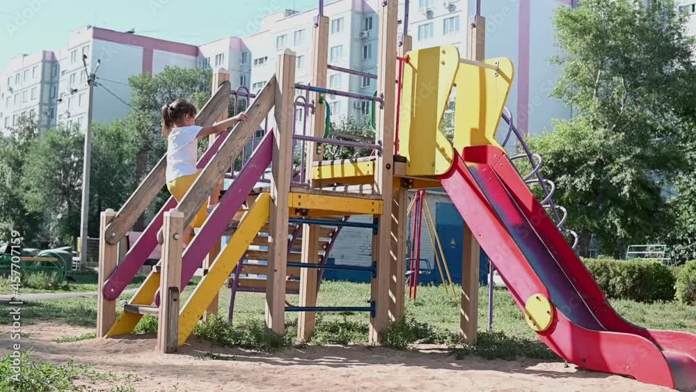 the girl runs to the playground on the slide. Summer vacation for children. the girl runs to the playground on the slide. Summer vacation for children.