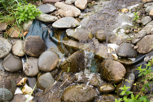 A stream flows over the stones in the garden