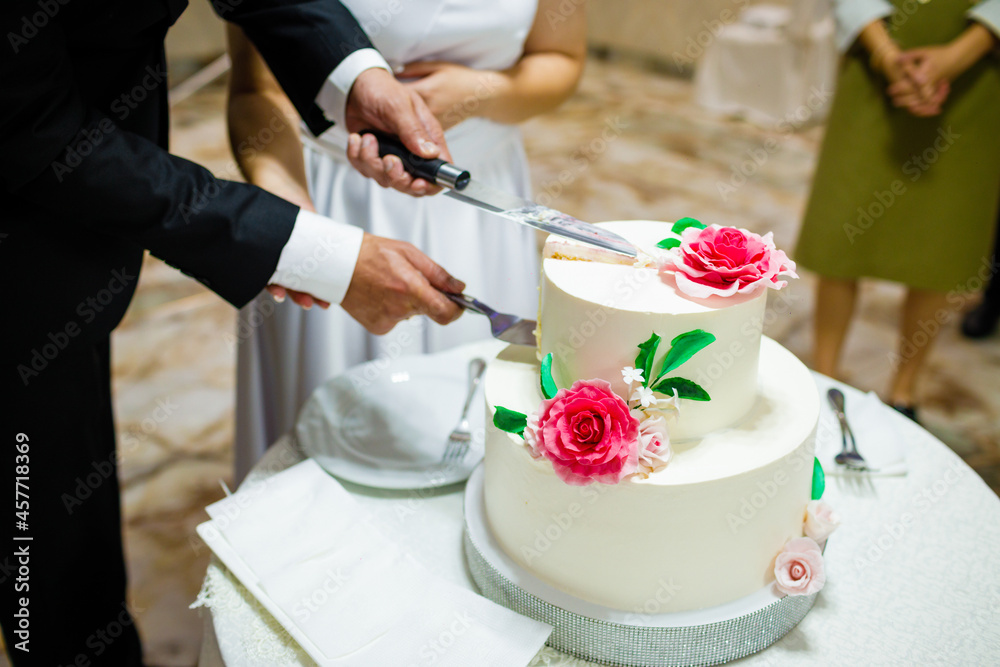 White wedding cake with flowers on a wooden table. White wedding cake with flowers on a wooden table.