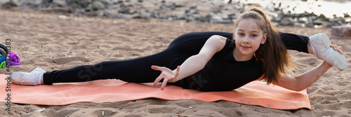 Girl gymnast trains on the beach by the sea. Photo series