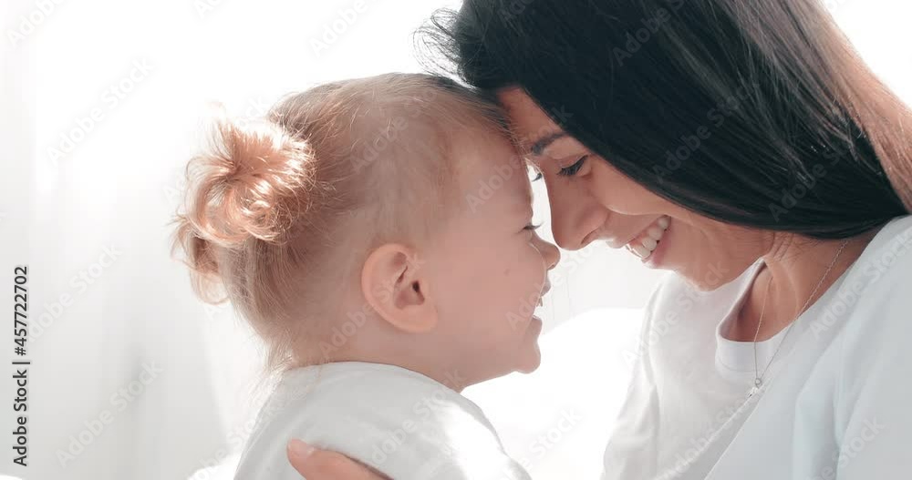 Mom and daughter cuddling together. Girls have fun and laugh. in slow motion Mom and daughter cuddling together. Girls have fun and laugh. in slow motion
