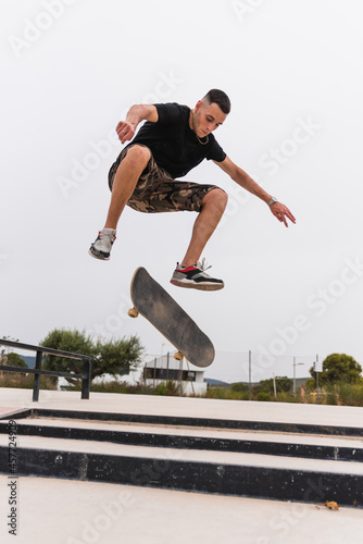 Skateboarder performing a trick in a skate park. © oscar