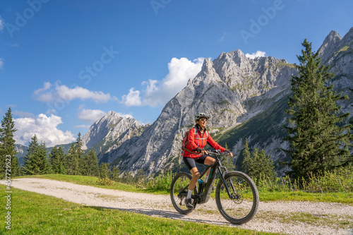 beautiful active senior woman with electric mountainbike in the spectacular Mountains of Raintal Valley, a side valley of Lechtal, Tyrol, Austria © Uwe