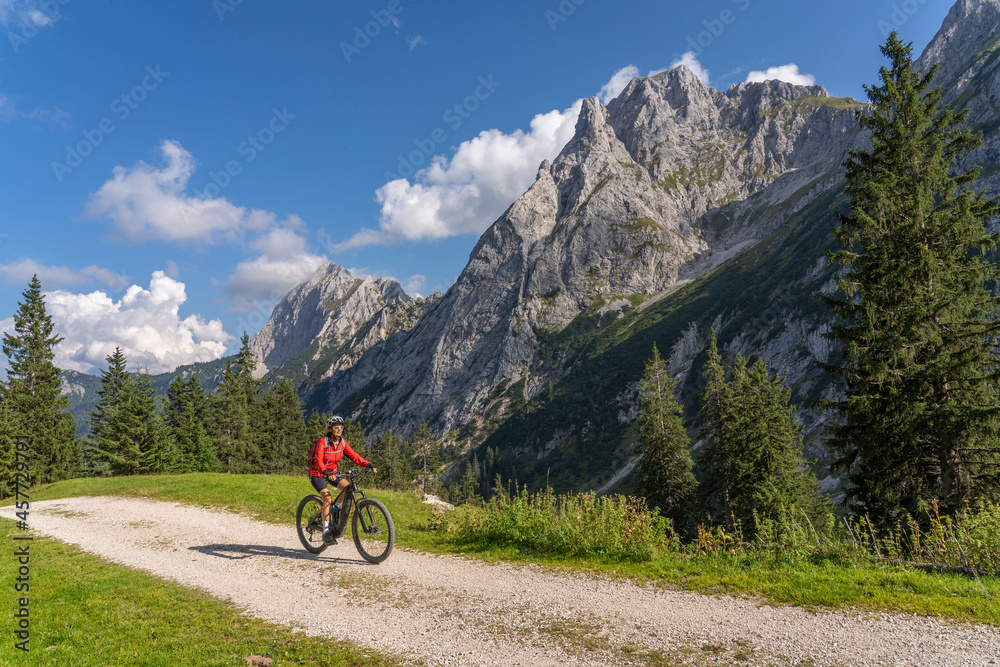 beautiful active senior woman with electric mountainbike in the spectacular Mountains of Raintal Valley, a side valley of Lechtal, Tyrol, Austria