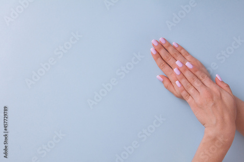 Beautiful woman pink manicure on creative blue background