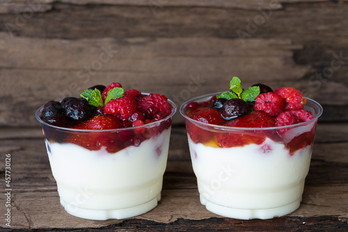 Fruit yogurt has strawberry raspberry blueberry canberry and honey greek white clean In bowl on a wooden background from top view. 