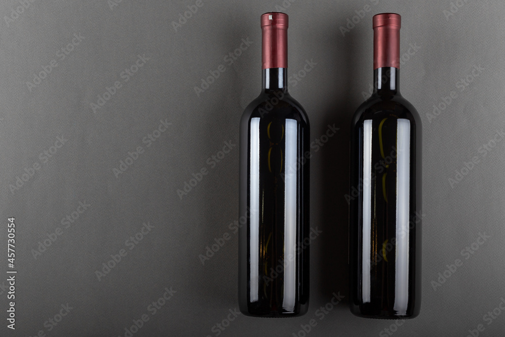 A corked two bottle of red wine on a gray office. Alcoholic drink. Winemaking concept. Space for text.