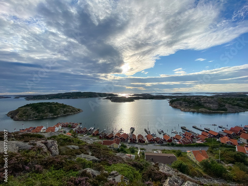 Small Swedish Houses at the coastline of Fjällbacka in Sweden with the sun and clouds in the background - Drone Perspective Architecture Photography 