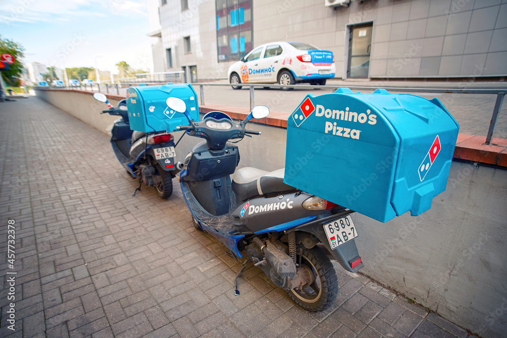 Minsk, Belarus. Oct 2020. Dominos delivery scooter parked near pizza  restaurant. Domino's pizza food delivery scooter with blue top case box for  pizzas take away. Domino's office delivery motorbikes Stock Photo