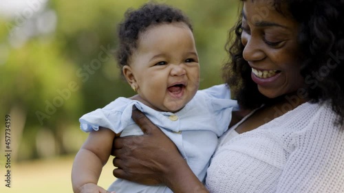 African American family Parent of newborn children take happy picnic hold or hug lovely in summer garden with trees. Weekend activity happy family lifestyle concept. take care with love stay together
