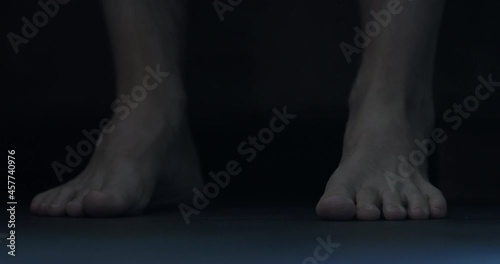 Slow motion man put his feet on floor in midnight and walk photo